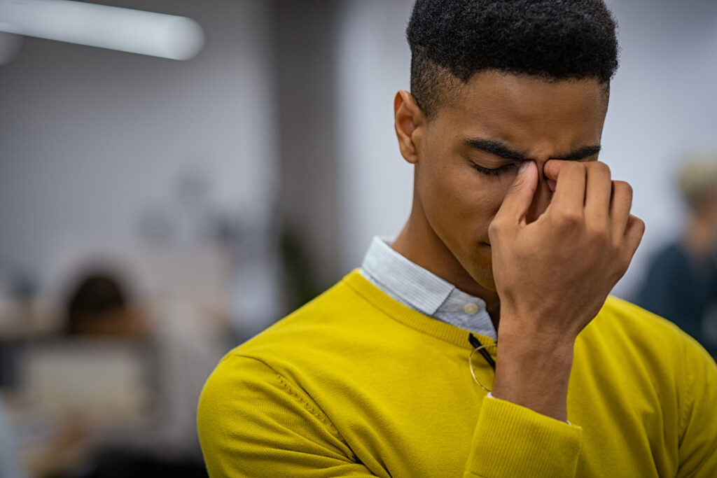 How Stress Affects Your Health, Stressed young man with migraine