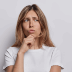 Woman thinking about going to the chiropractor.