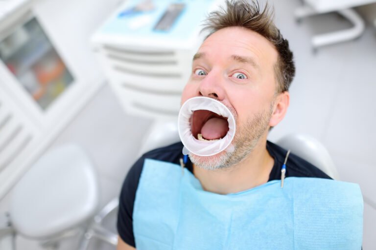 Frightened patient in the chair on dental clinic - post-dental headache and neck pain.